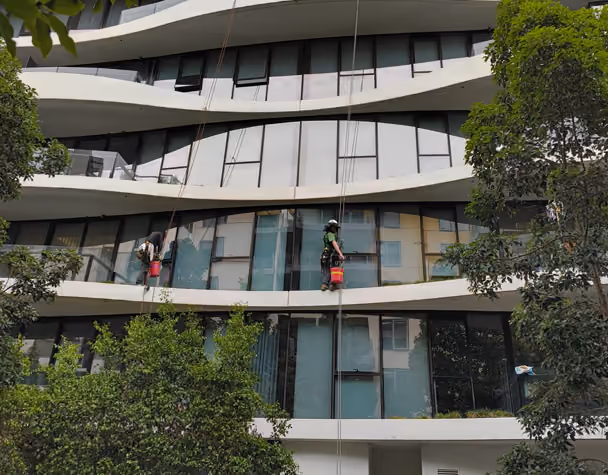 Bax Clean rope access technicians cleaning windows on a multi-storey residential building
