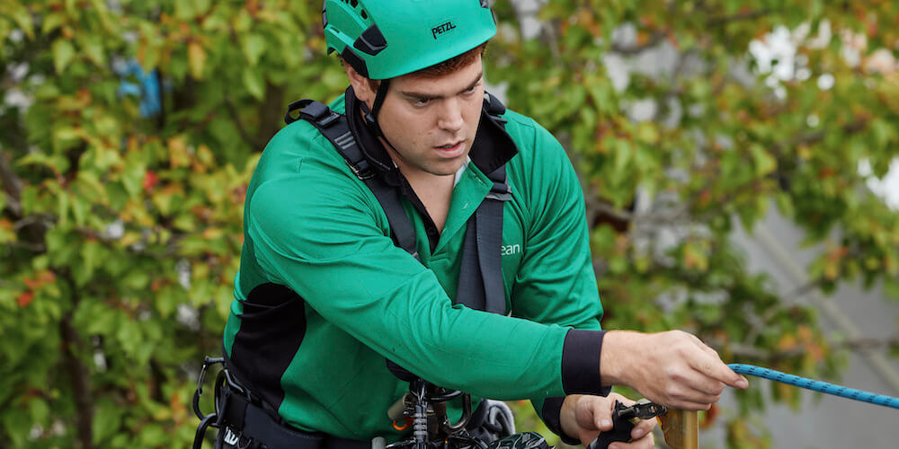 Rope access technician rigging safety equipment before high-level gutter cleaning in Prahran.