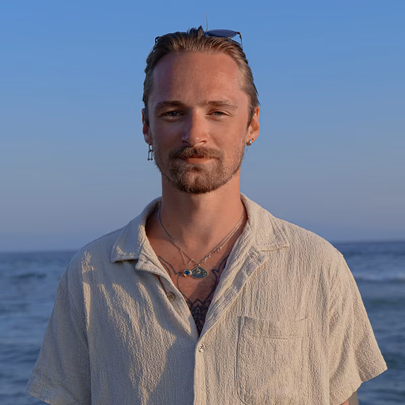 Portrait of Lucas Maniez, founder of Graphikas, standing by the sea