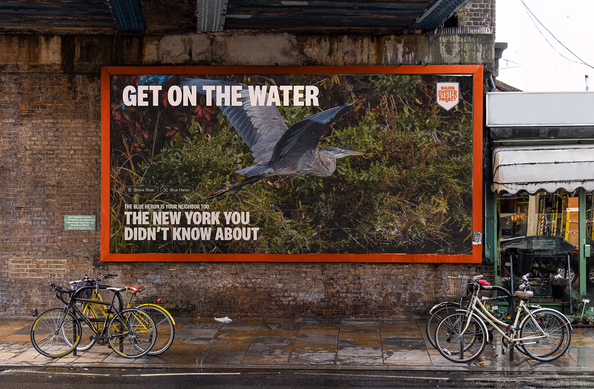 Billion Oyster Project billboard: “Get on the water” with a great blue heron in flight