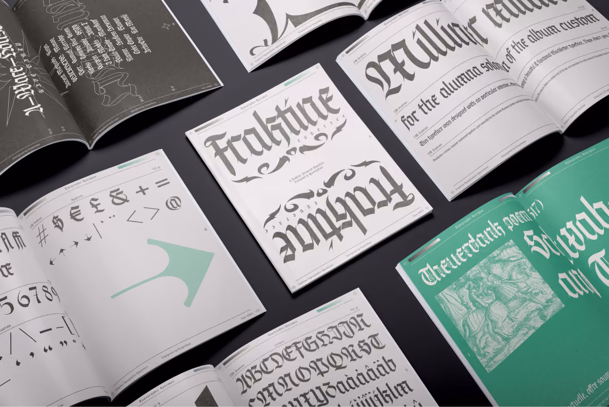 Fraktine blackletter typeface specimen booklets laid out on a dark surface