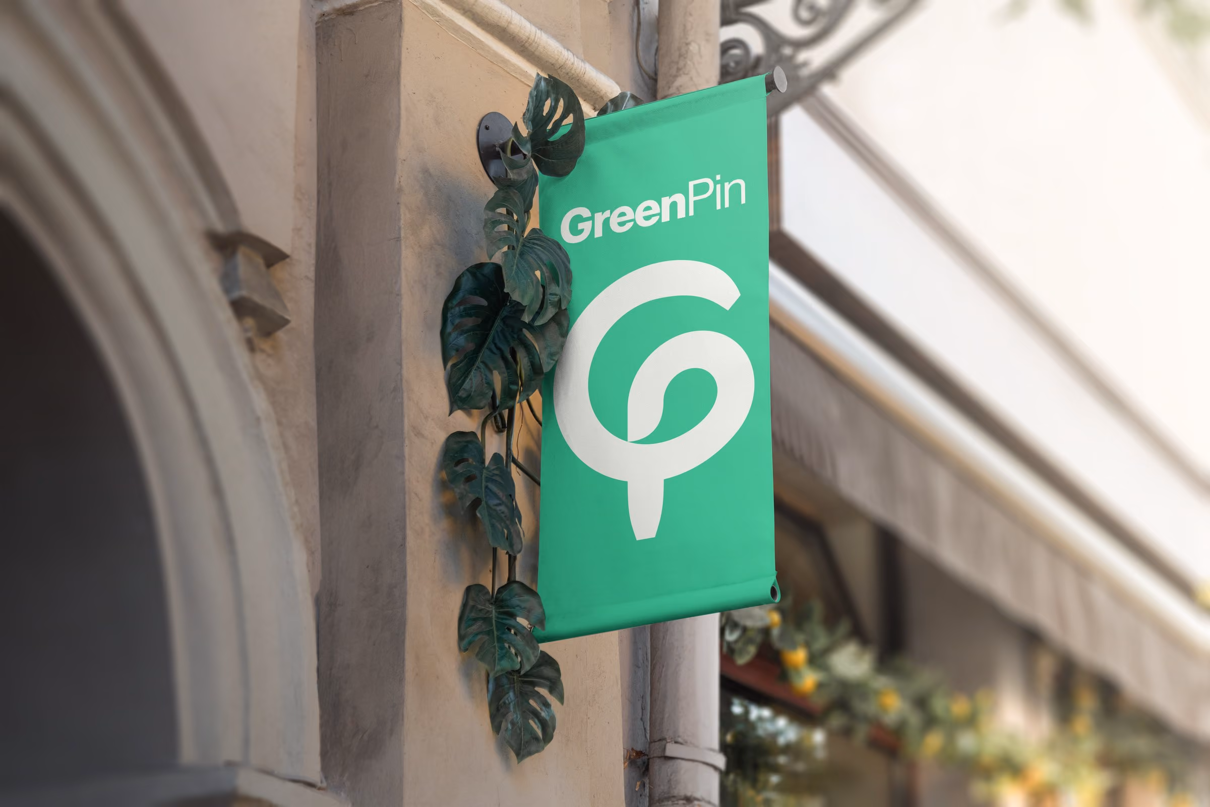 GreenPin hanging shop sign: the green pin logo and wordmark on a banner beside a stone archway
