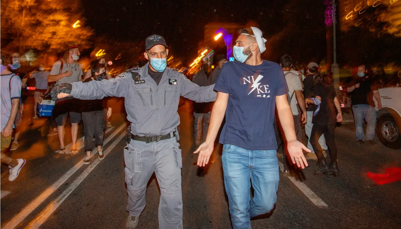 שוטר מפנה מפגין בירושלים בקיץ שעבר. צילום: שאטרסטוק