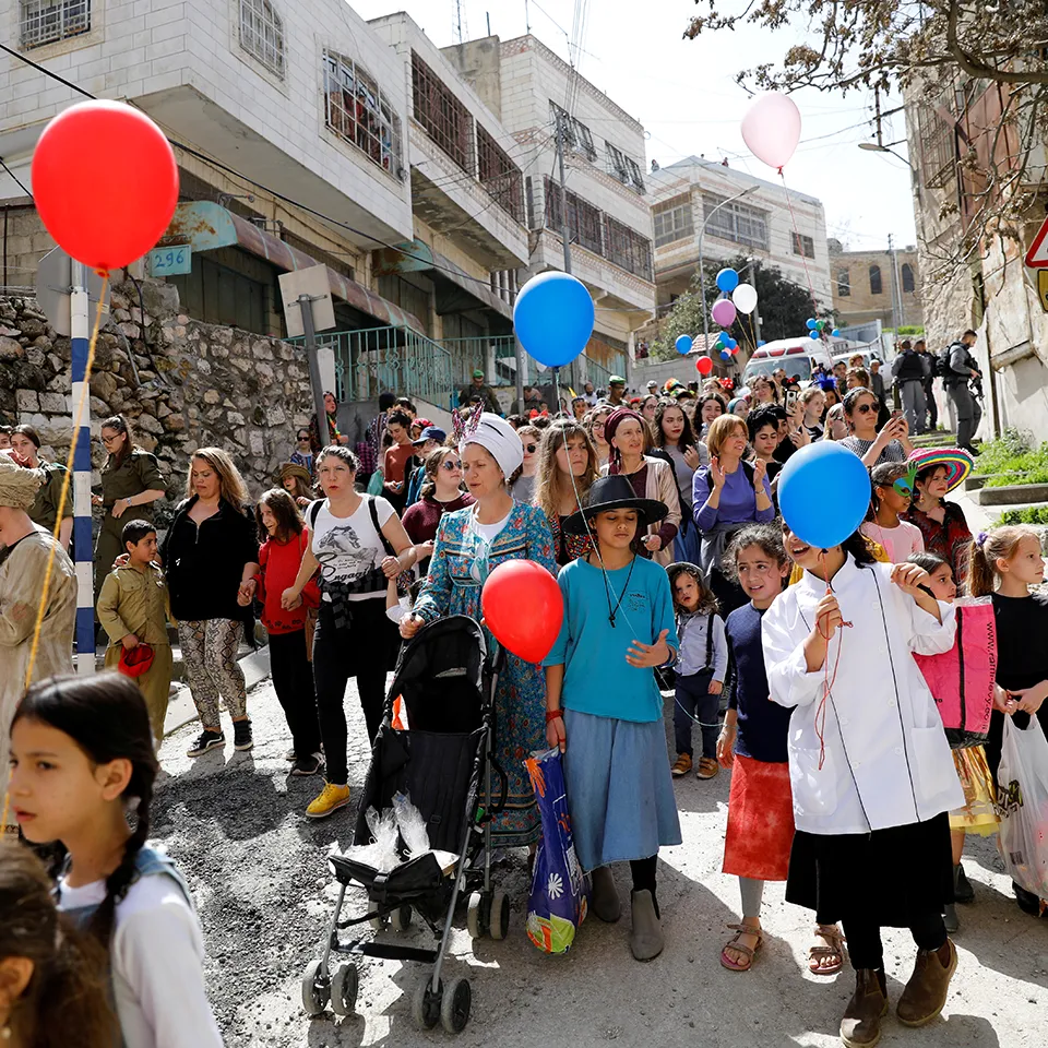 במשרד אומרים שלחברון יגיעו עולים פוטנציאלים. מתנחלים צועדים בפורים בחברון (צילום: רויטרס)