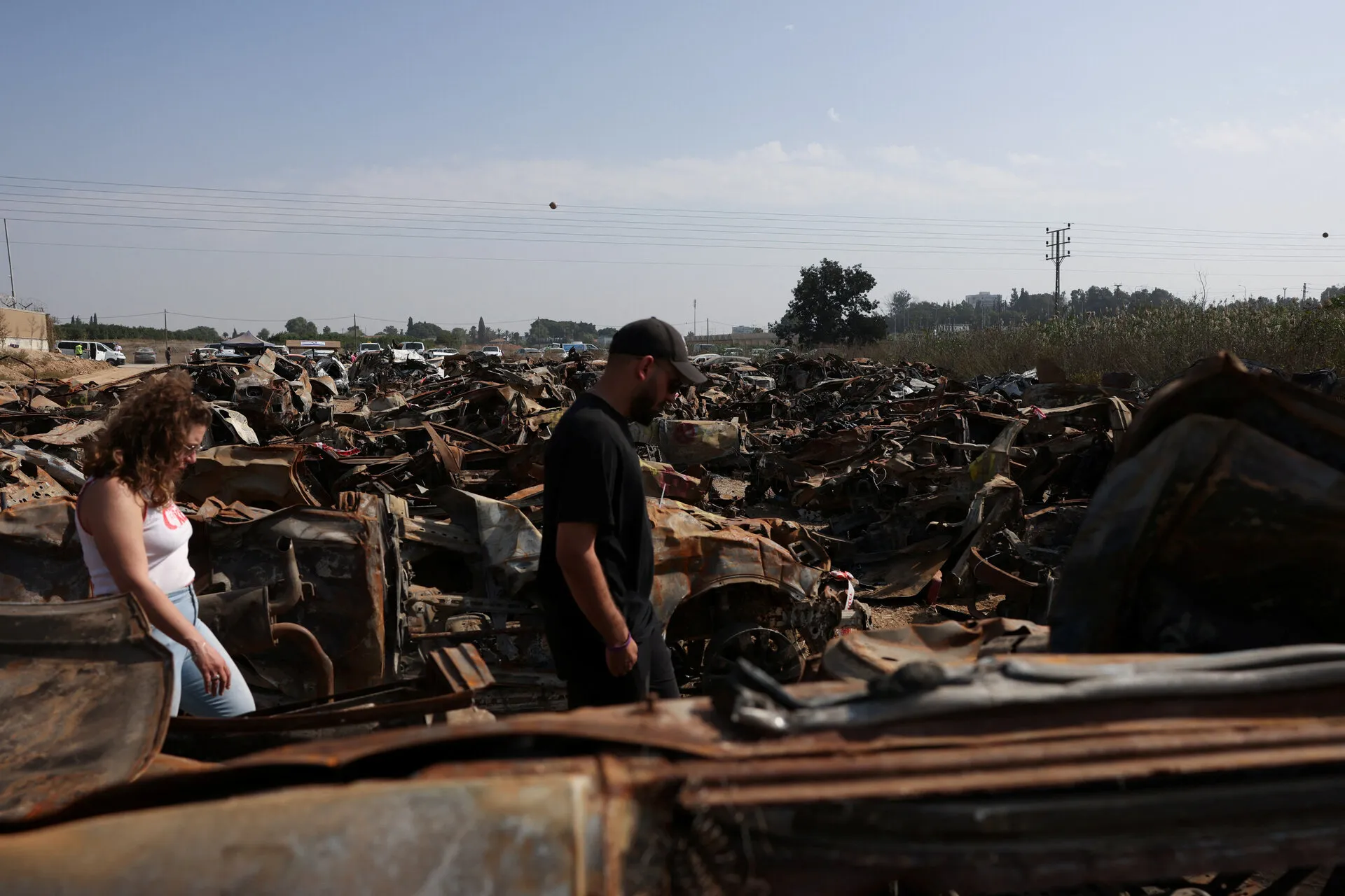 Two survivors of the massacre walking between the burnt-out vehicles. The people depicted are not related to the article. Credit: Reuters