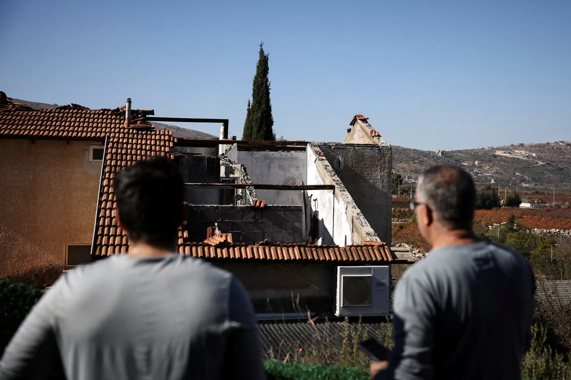 Residents of Metula in front of a house damaged by Hezbollah. Photo: Reuters