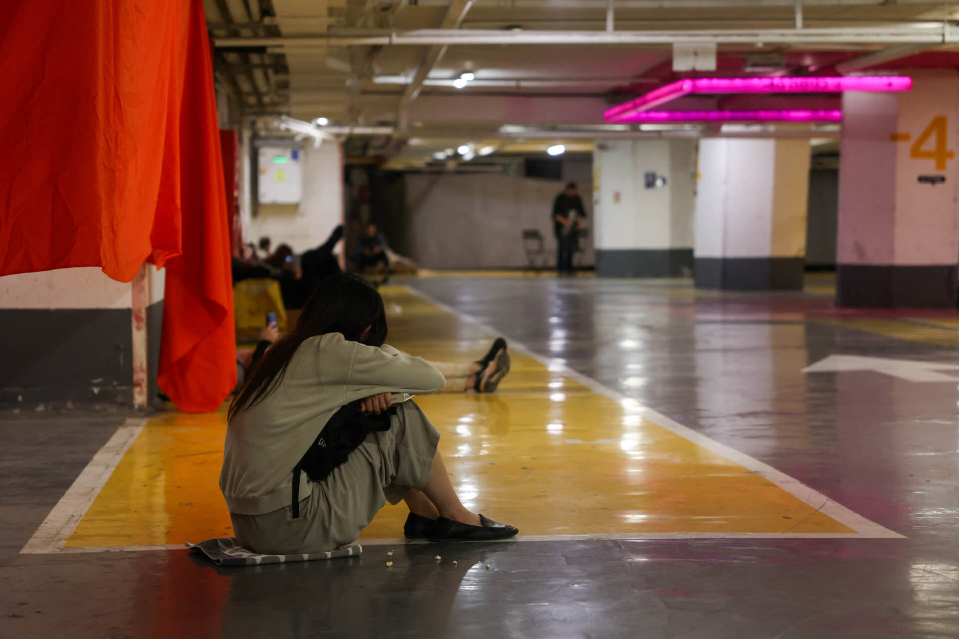 צעירה בחניון בת"א שמשמש מקלט. צילום: רויטרס