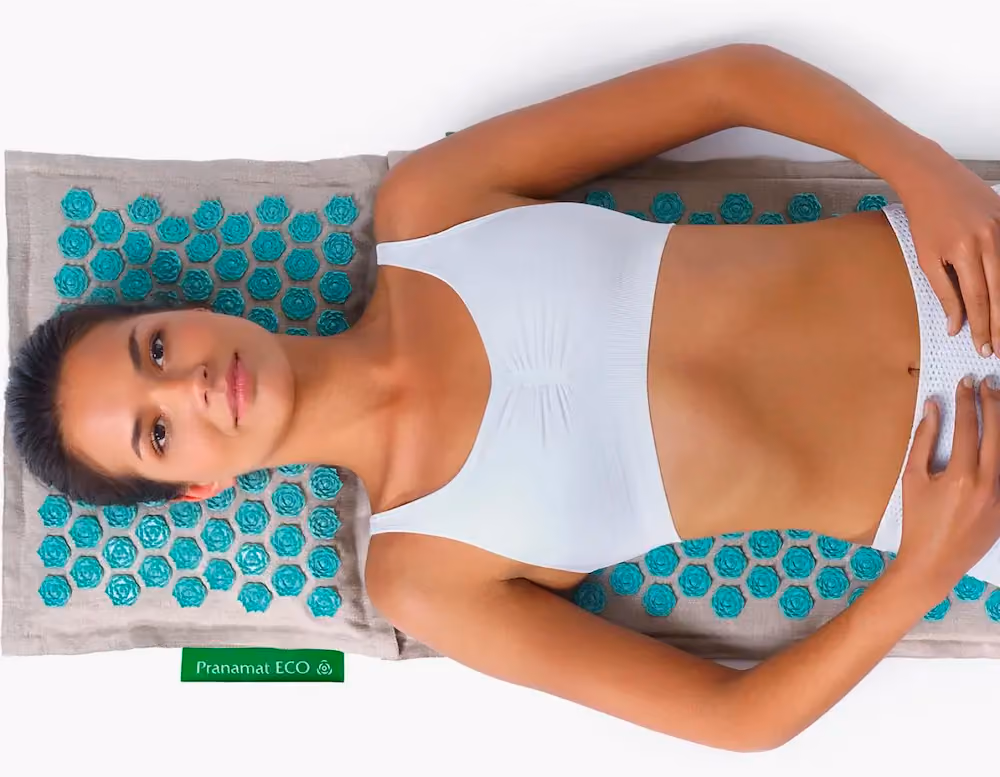 A person lying on a Pranamat acupressure mat.