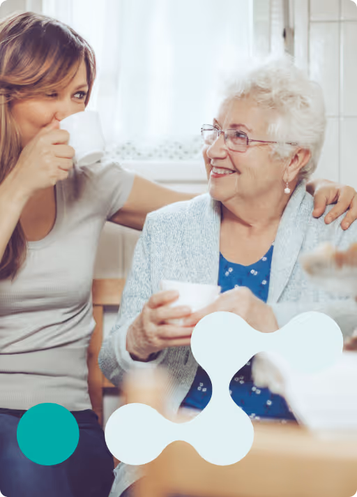Caregiver and older woman enjoying tea together