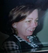 Image of Lee side on from the shoulders up wearing a check shirt and smiling 