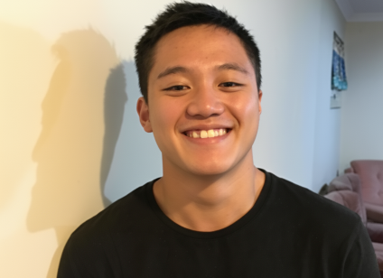 Portrait of Daniel smiling at the camera wearing a black shirt
