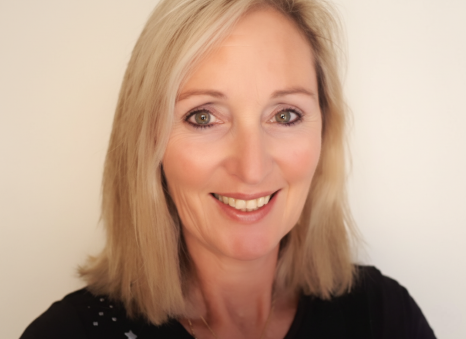 Portrait of Cheryl wearing a dark shirt smiling at the camera