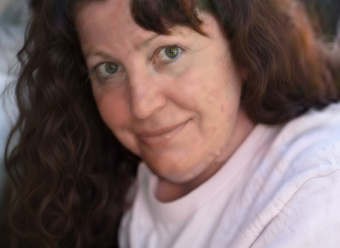 Portrait of Melissa in a pink jumper looking at the camera
