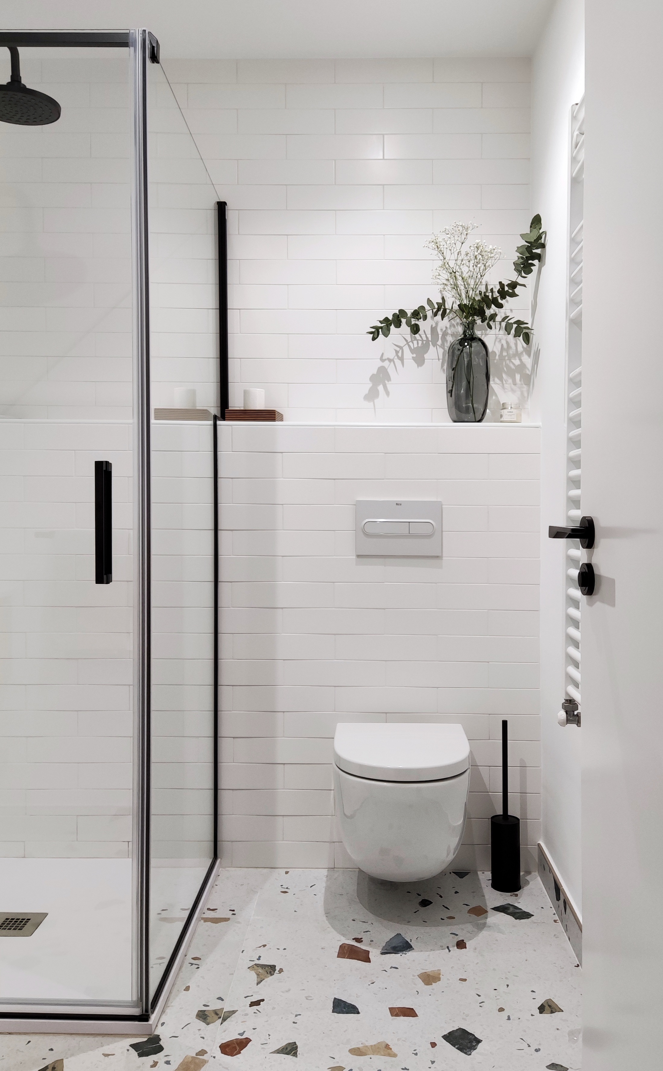 Baño de invitados con pavimento tipo terrazo de colores.