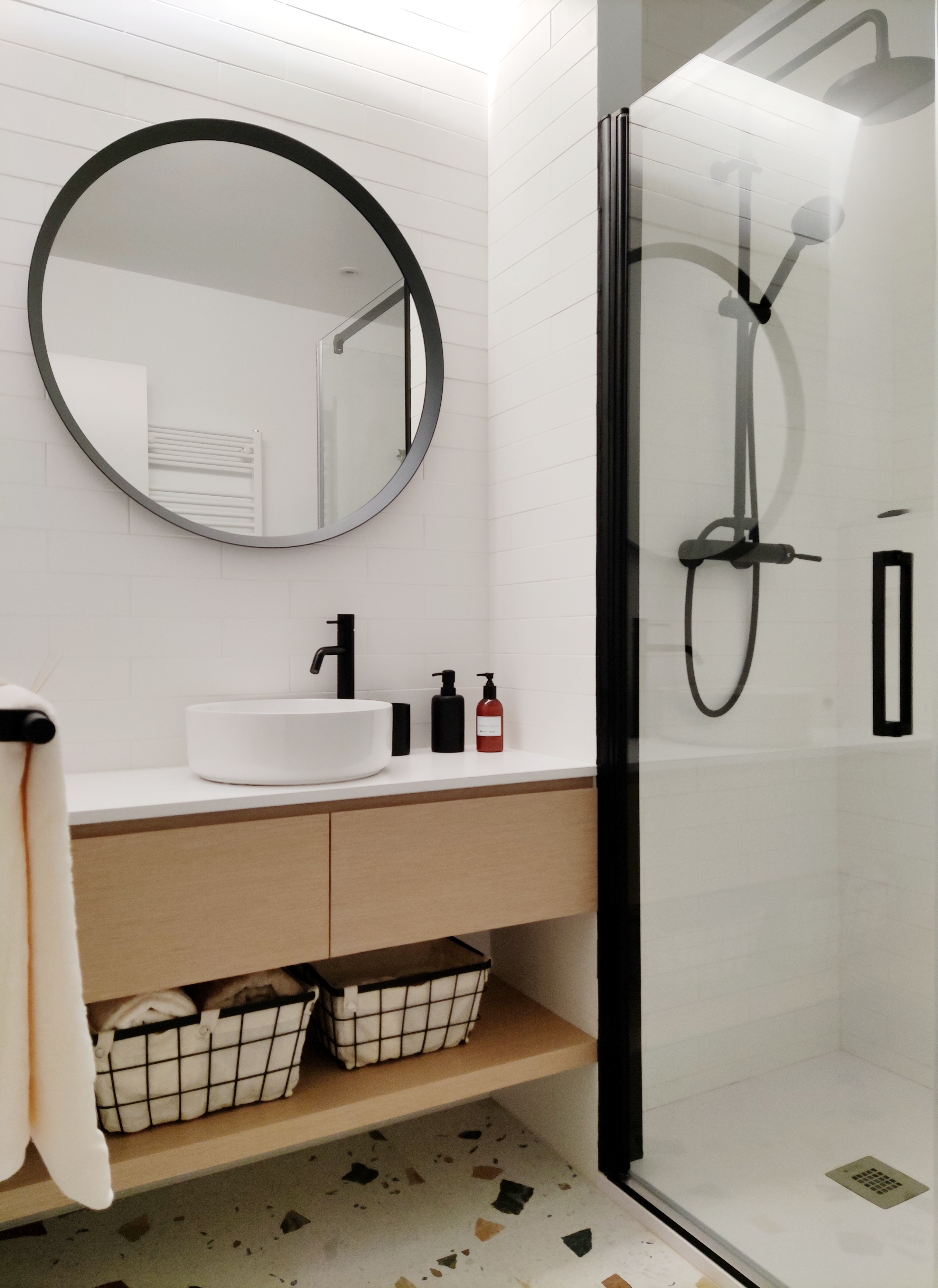 Baño de invitados con pavimento tipo terrazo de colores.