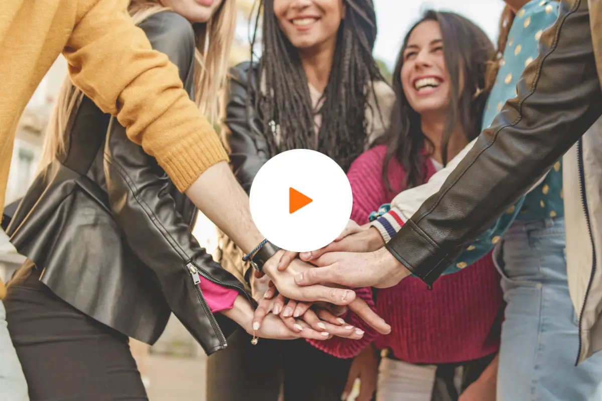 Group of women joining hands in a show of unity and support, symbolizing strength, awareness, and encouragement for those affected by cancer.
