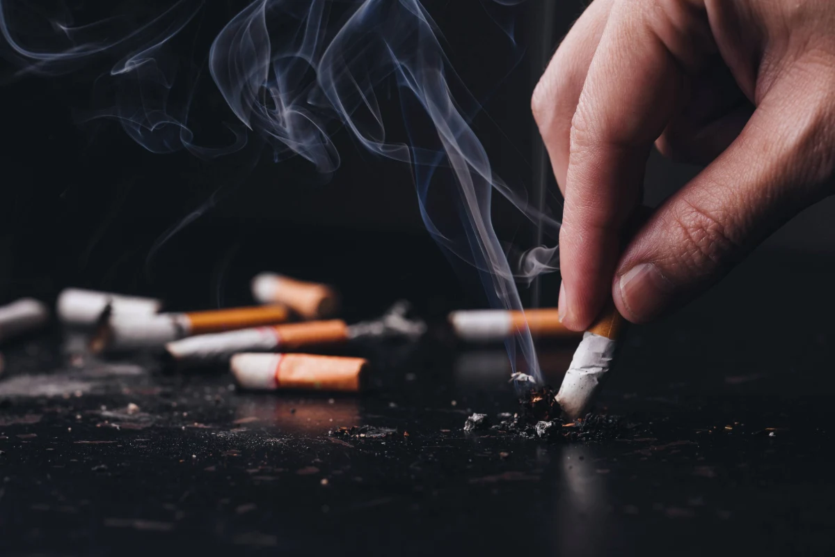 Person putting out multiple cigarettes to show they want to quit smoking.