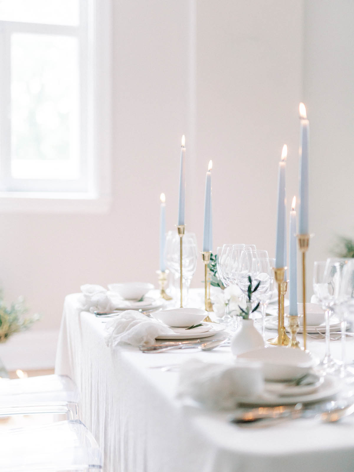 Reception table set with powder blue taper candles in brass holders