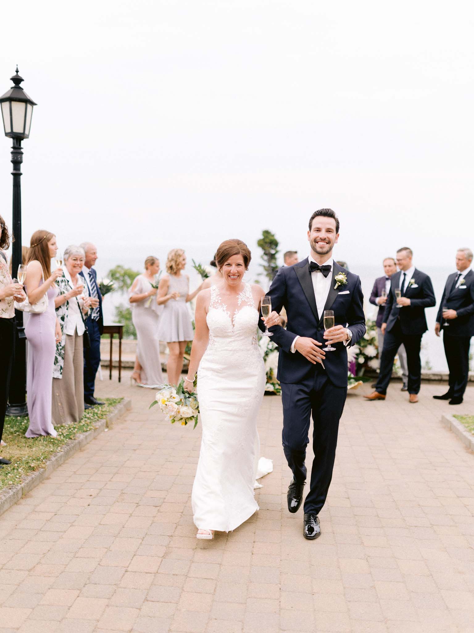 Bride and groom walking back through their guests with champagne in hand