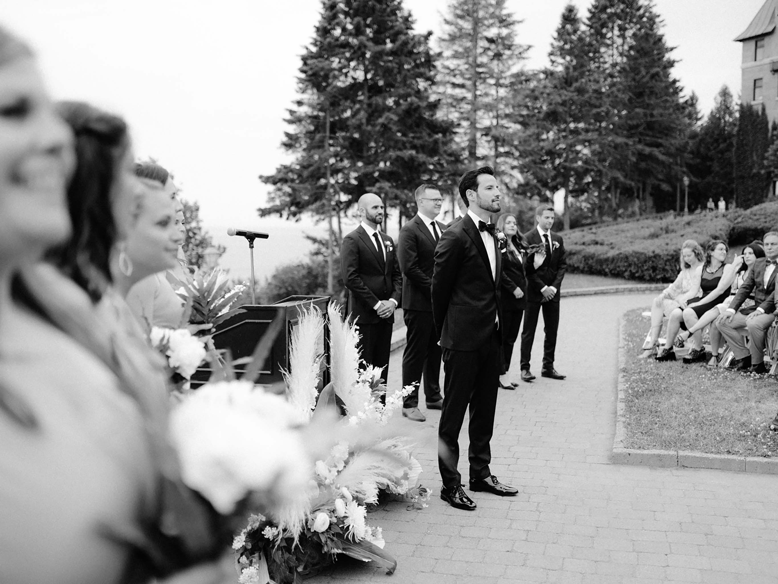 Groom waiting at the front of the ceremony as the bride comes down the aisle