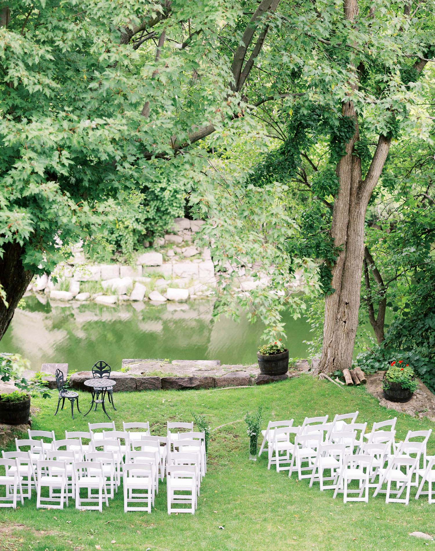 Riverside ceremony at Le Café de l'Horloge in Rigaud, white folding chairs on the lawn above the water