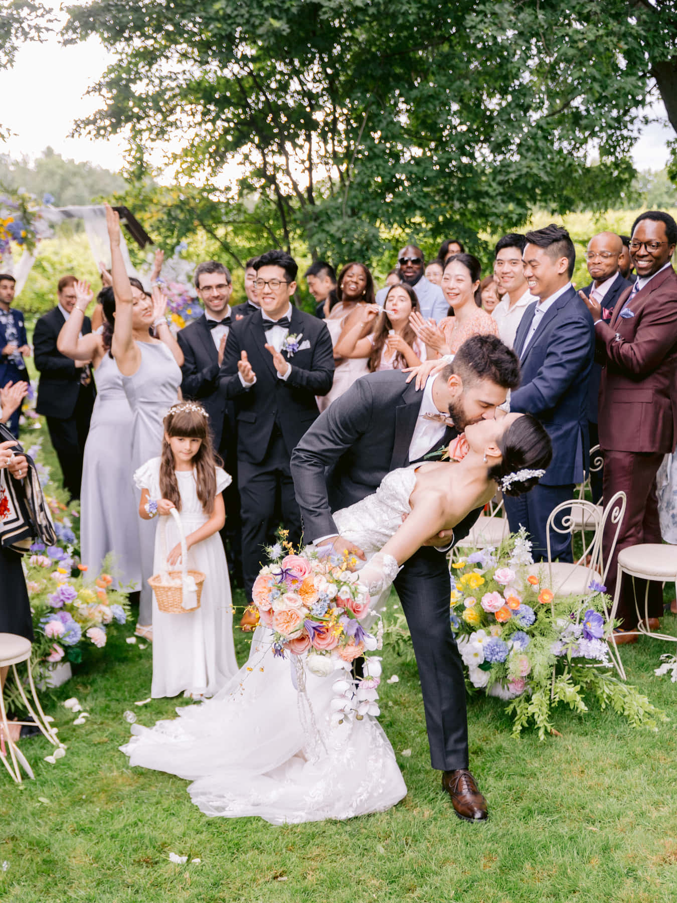 Marié renversant la mariée pour un baiser dans l'allée sous les acclamations des invités