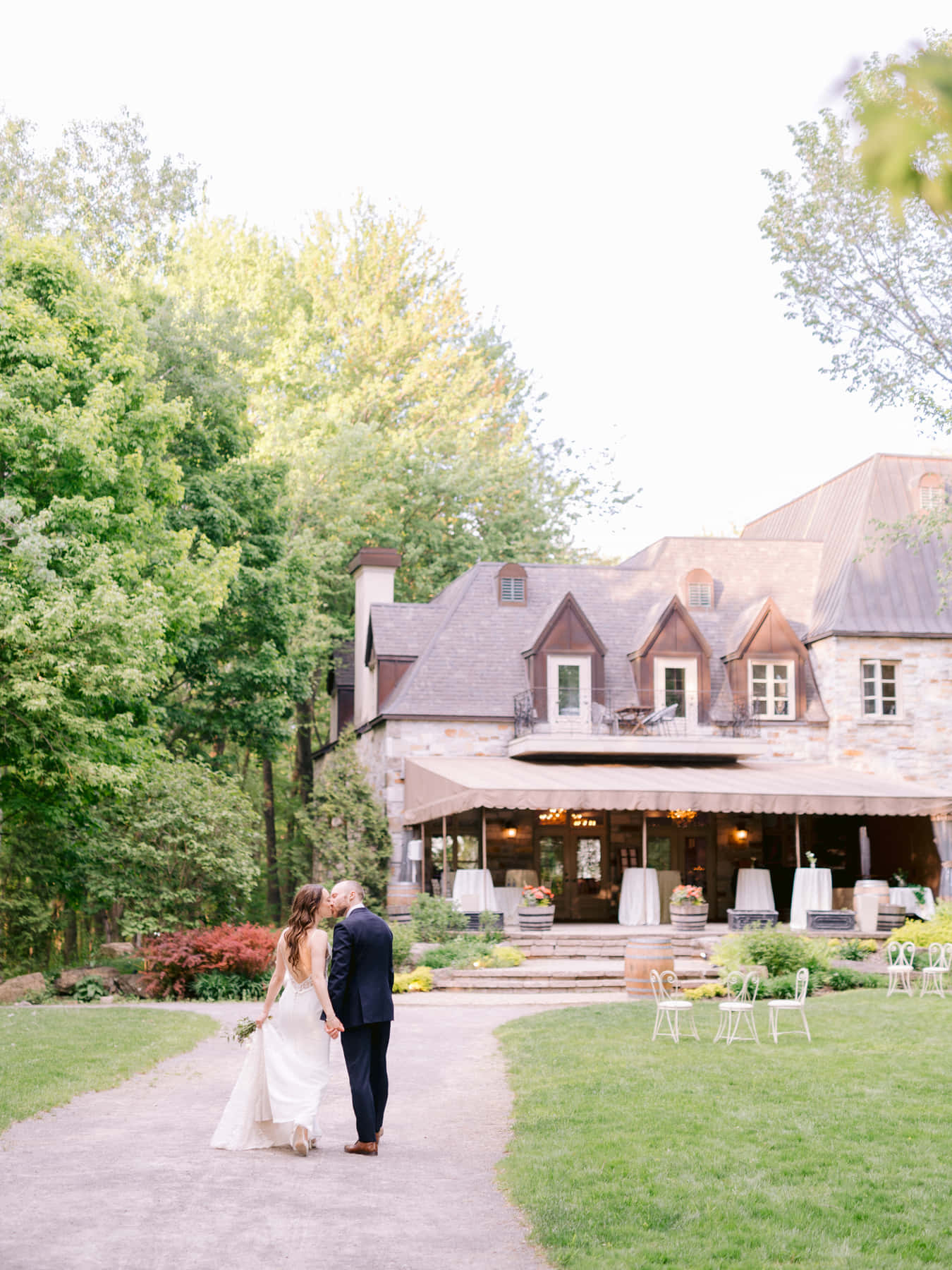 Mariés s'embrassant sur le sentier du jardin, sous la terrasse du château, en soirée
