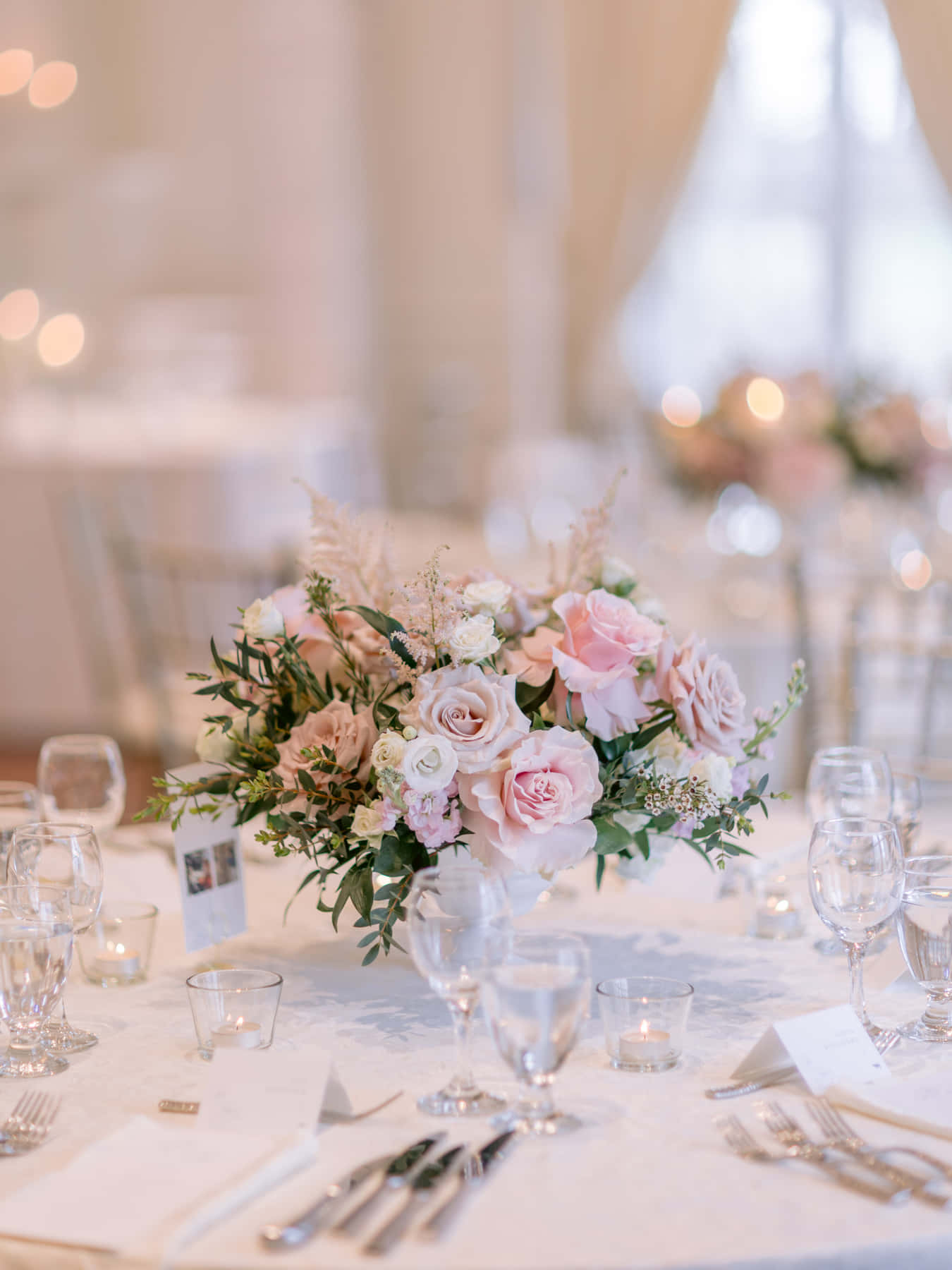 Table de réception dressée de roses, de verres de cristal et de chandelles