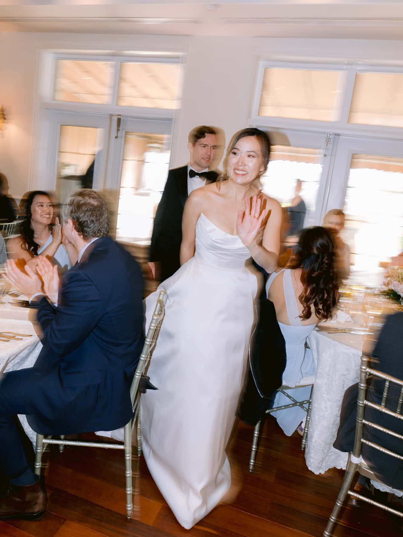 Mariée saluant les invités en passant entre les tables de la réception