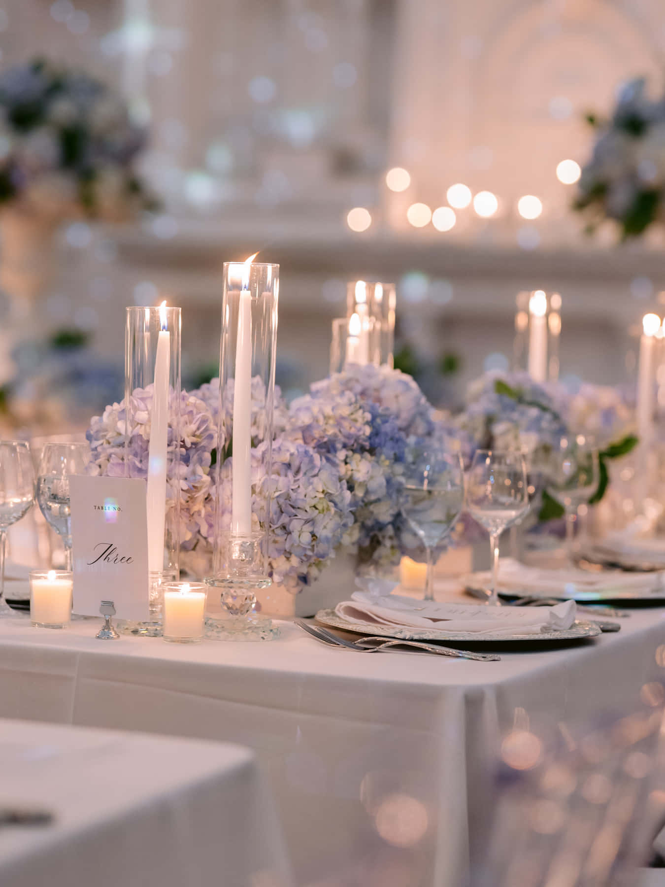 Candlelit table with hydrangeas and tall taper candles