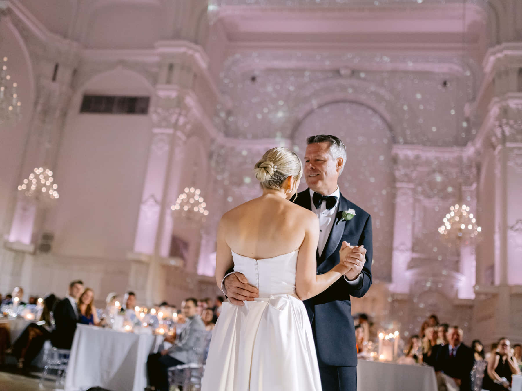 Bride sharing a slow dance among the reception tables
