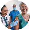 A diverse group of adults (different ages and ethnicities) smiling after getting vaccinated at a clinic, each with a small bandage on their upper arm. Include a nurse or provider in the background giving a flu shot in a clean, friendly environment.