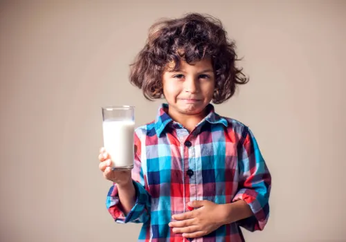 Lactose intolerant child with a stomach ache after drinking a glass of milk.