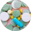 Capsule and tablet pills scattered across a pink background.