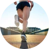 Low-angle view of a woman jogging on a track, highlighting her calf muscles — the body’s ‘second heart’ that supports circulation and heart health.