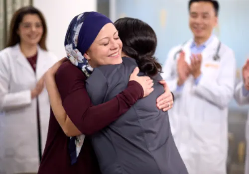 A breast cancer survivor hugs her caretaker inside Gregory Rhodes MD Cancer Center, symbolizing hope, recovery, and compassionate support.