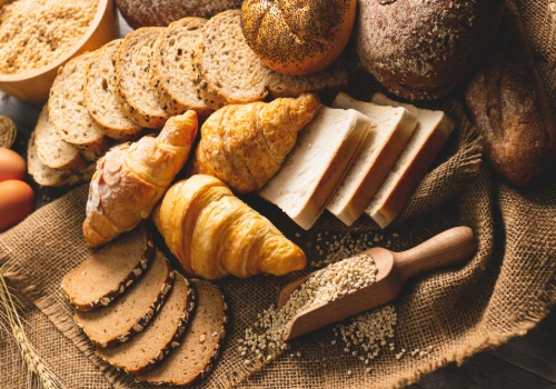 A variety of carbohydrate-rich foods like bread, bagels, rice, and pasta — showing how all carbs eventually turn into sugar and affect blood glucose.