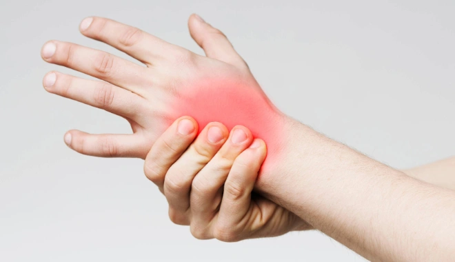Person holding their wrist with a red-highlighted pain area, illustrating hand and wrist discomfort such as carpal tunnel syndrome or tendon injury.