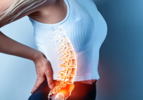 Person holding their lumbar area in discomfort, showing signs of a pinched nerve