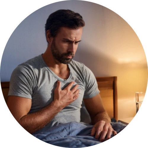 A patient holding their chest in discomfort, sitting upright in bed at night, with a glass of water and antacid bottle on the nightstand.