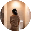 A woman staring anxiously at her bathroom toliet.