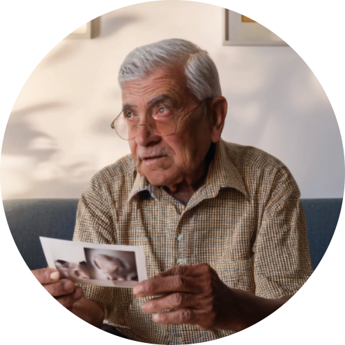 Elderly person looking confused while holding a photo.