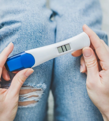 Woman anxiously holding a positive pregnancy test
