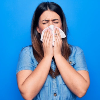 Woman blowing her nose to try to alleviate her sinus pressure