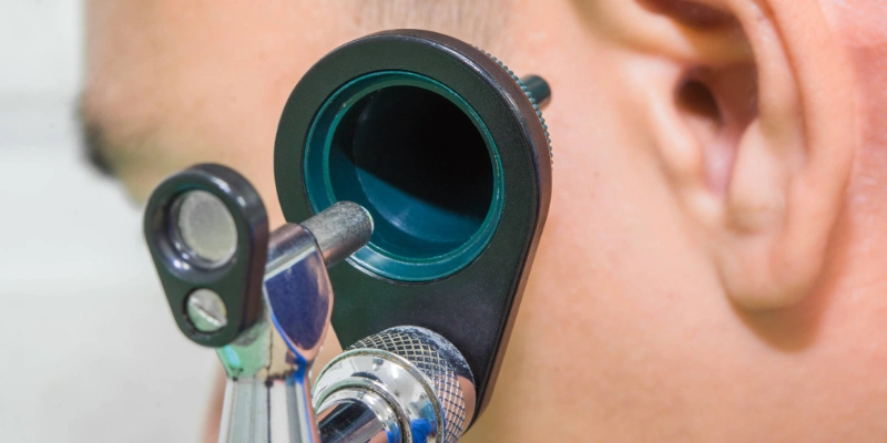 Doctor using an otoscope to examine an infected ear
