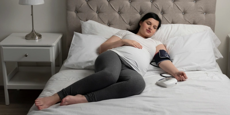 Pregnant woman monitoring her blood pressure at home