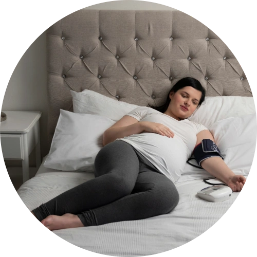 Pregnant woman monitoring her blood pressure at home