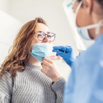 Woman receiving a nasal swab for COVID-19 testing