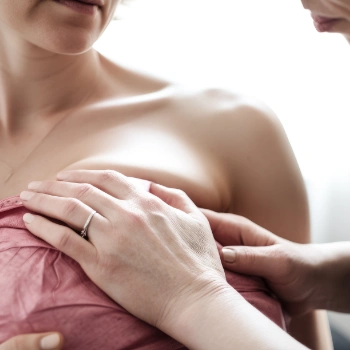 doctor examining a women's breast for lumps and tumors
