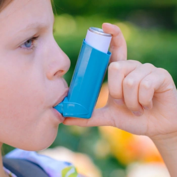 Young girl using an inhaler for her asthma